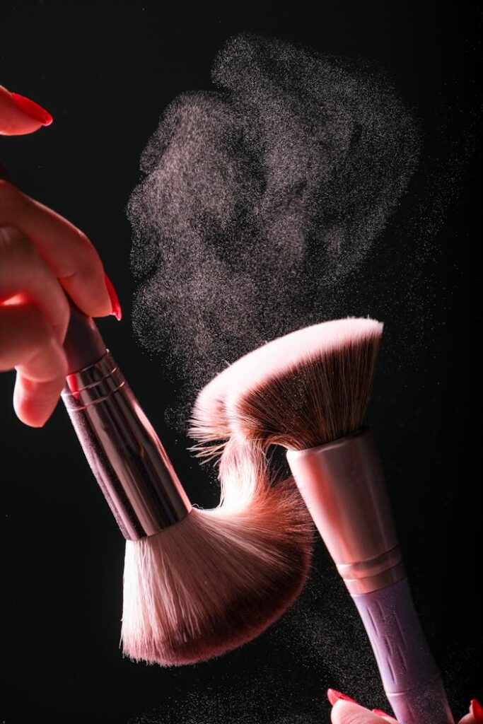 Dynamic studio shot of makeup brushes creating a powder burst against a dark background.